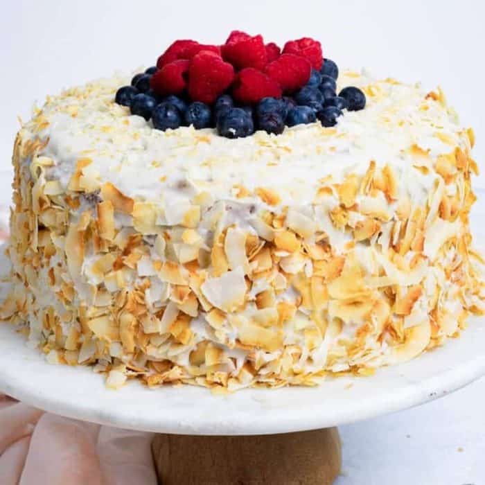 Transport your taste buds to the tropics with this vegan coconut cake, a moist and airy cake bursting with coconut flavors. This is thanks to its mix of coconut milk, coconut extract, and coconut shreds. 