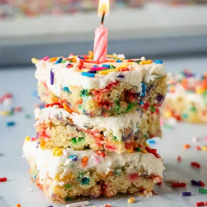 cheerful rainbow sprinkles are baked into a fluffy white cake and speckled all over the smooth and creamy vanilla frosting