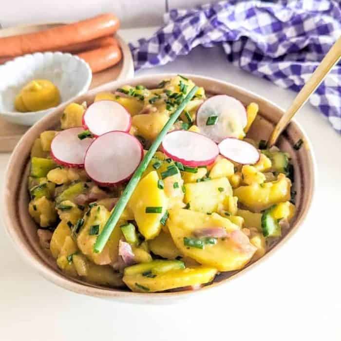 start by sautéing your onions and boiling your potatoes until tender. Mix them with cucumber afterward, and drench the ingredients in a homemade vinaigrette featuring broth, vinegar, mustard, and a hint of apple juice.