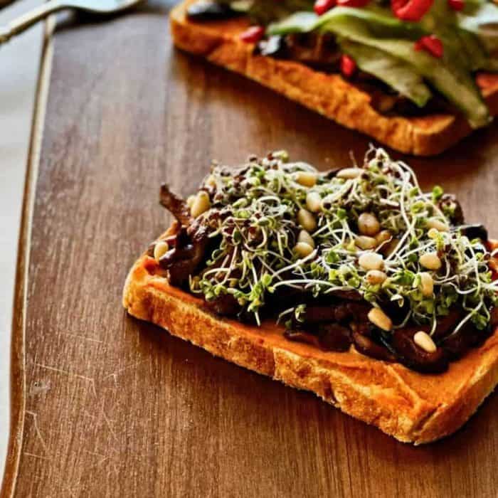 a photo of faced mushroom sandwich isolated on a wooden surface
