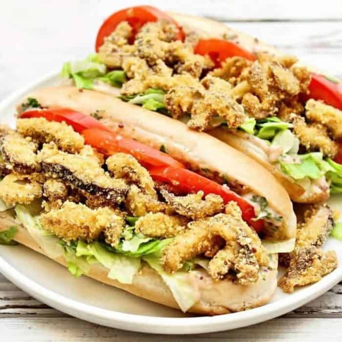 a white round plate full of mushroom po boys sandwich