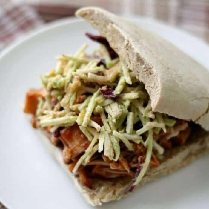 a photo of pulled bbq jackfruit tahini slaw sandwiches on a white plate