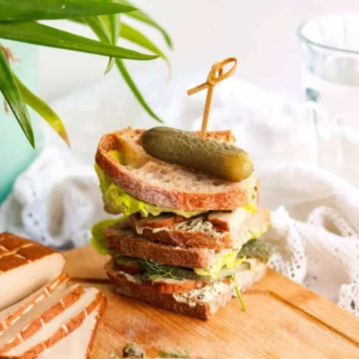 a photo of smoked tofu sandwich on a wooden board