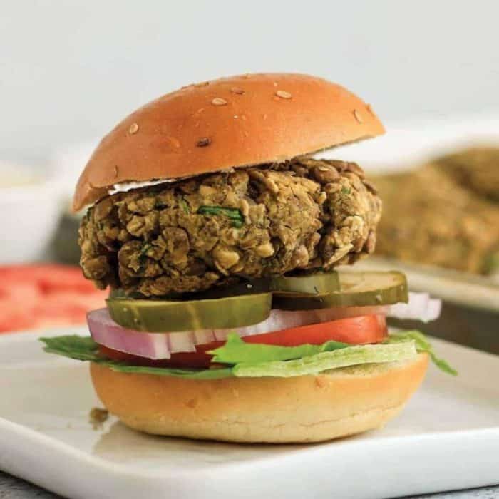 a photo of a burger with lentils and chia on a square plate