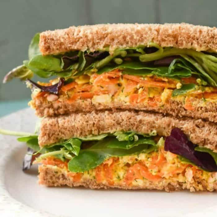 a close up photo of vegan cheese sandwich on a white plate