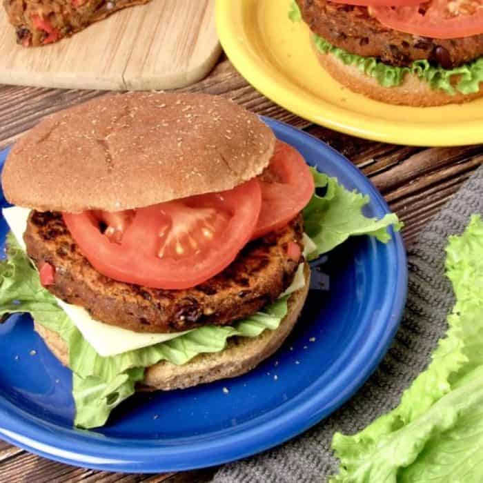 a photo of black bean burger sandwhich on a blue round plate