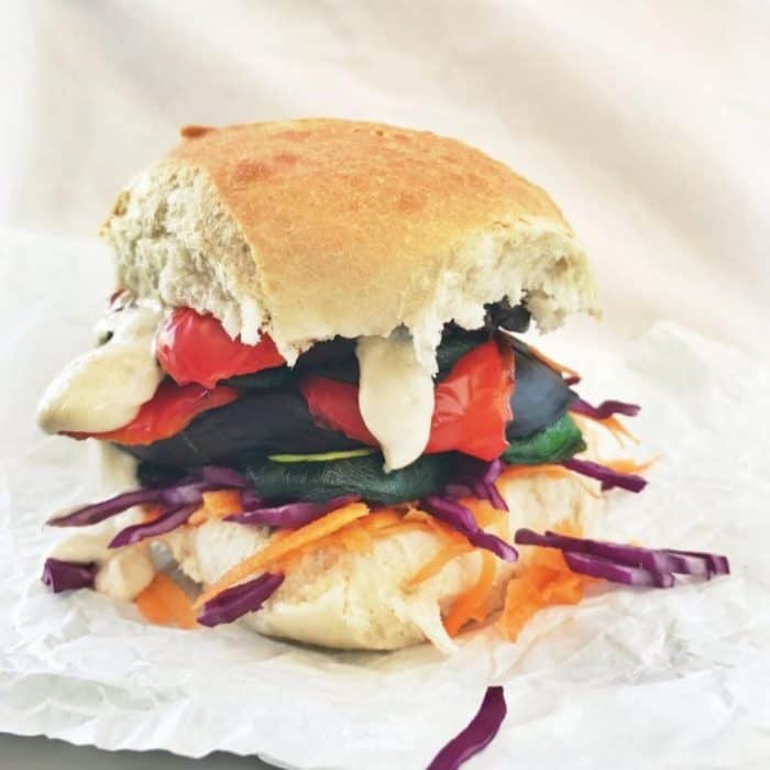 a photo of grilled rainbow vegetable sandwich o a white background
