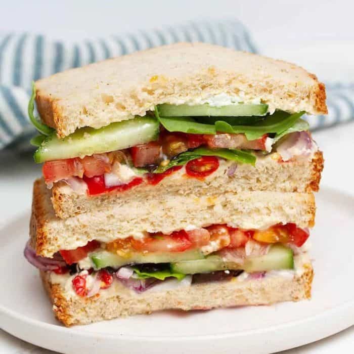 a photo of panera mediterranean veggie sandwich on a white round plate