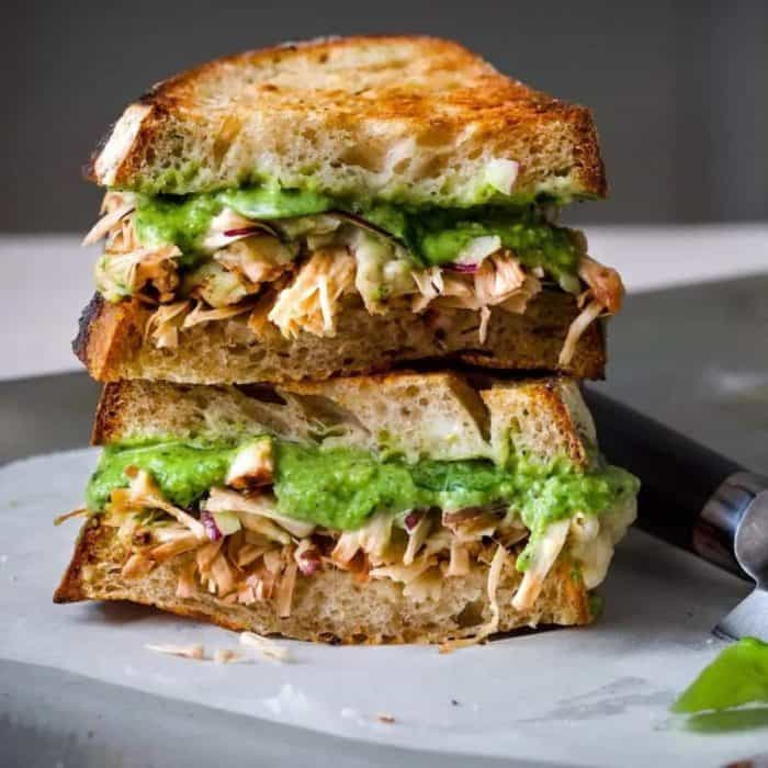 a photo of vegan pesto jackfruit sandwich on a gray surface