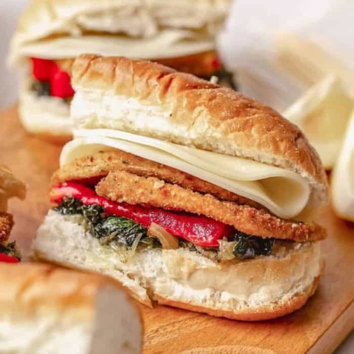a photo of primos vegan sandwich on a wooden chopping board
