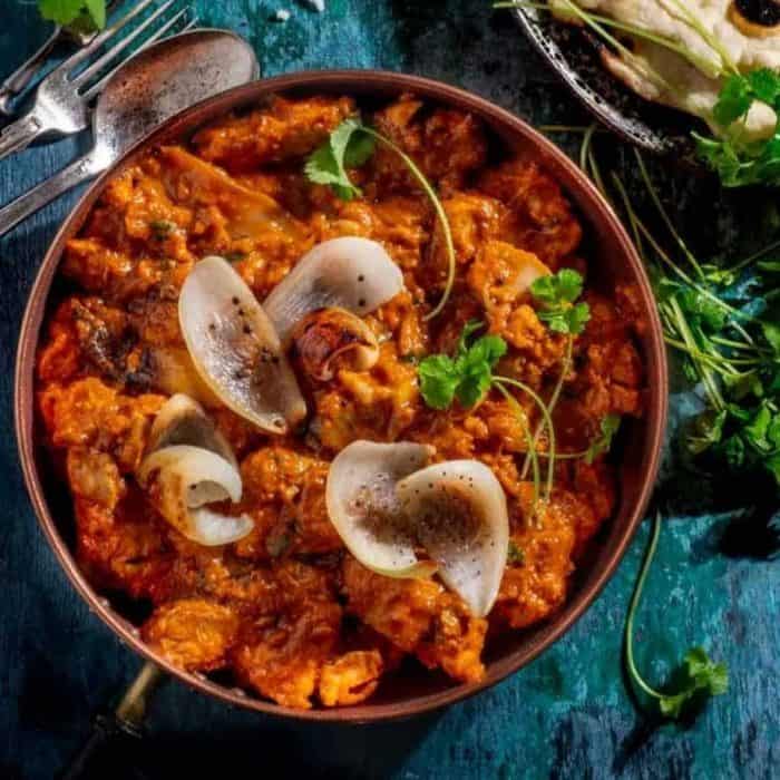 This chicken dopiaza features seasoned and marinated chicken pieces with caramelized onions that add a sweet depth, along with a medley of coriander, cumin, and a hint of chili powder in the thick, savory sauce. 