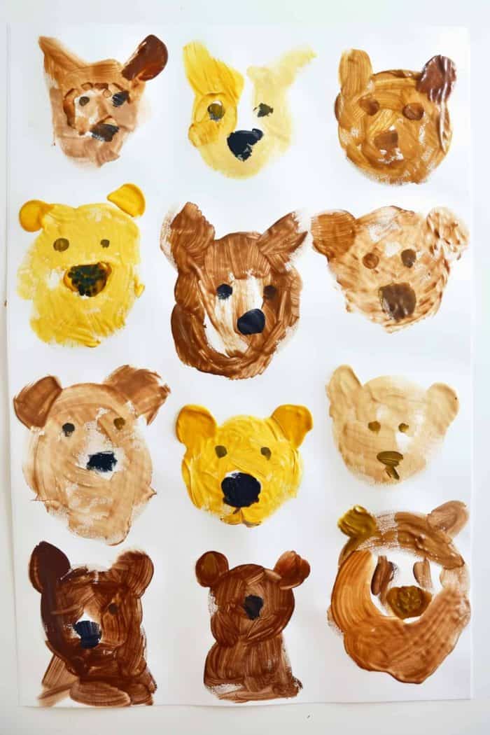 Finger-painted animal faces of bears in brown and yellow colors