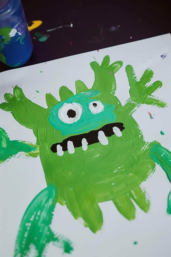 A finger painting of a scary monster with big eyes and teeth