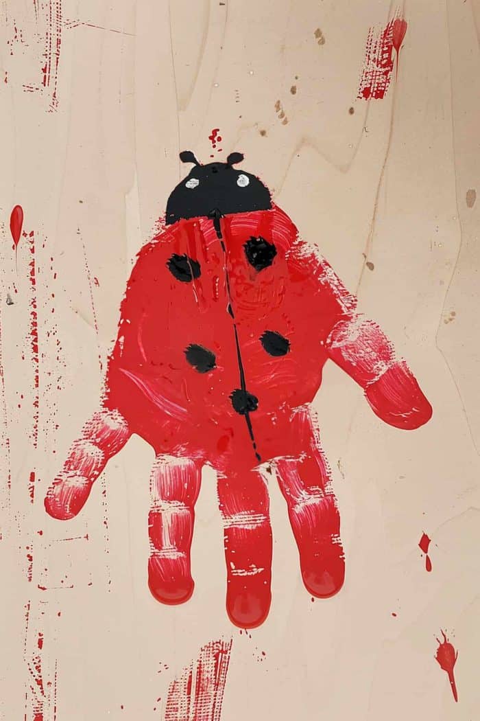 Turn a simple handprint into an adorable ladybug by using red paint for the body. After pressing the painted hand onto paper, let it dry, then add black spots, legs, and antennae with a brush or markers.