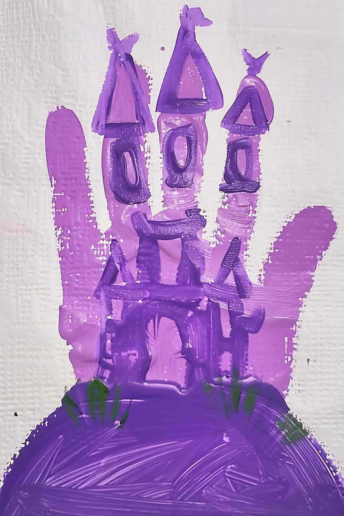 Construct a castle using a purple handprint for the towers, with fingers pointing upwards to create turrets. 