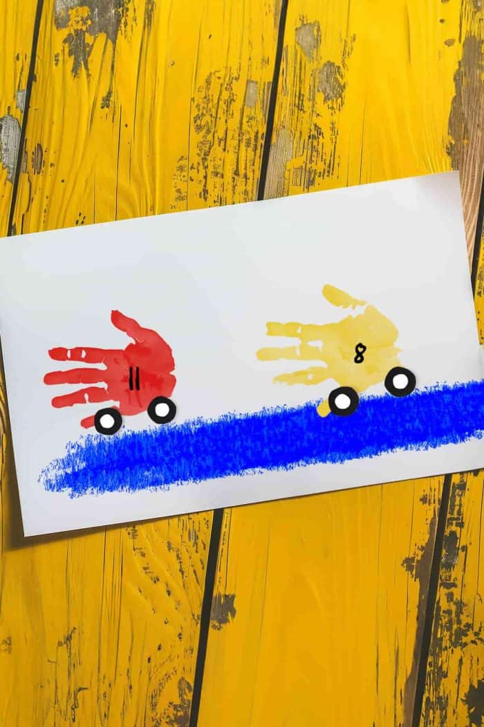 Let your child paint their hand with a bright color like red, yellow, or blue, then press it onto a sheet of paper to form the car’s body.   They can create details like wheels, numbers, and a road for a fun depiction of an exciting race.