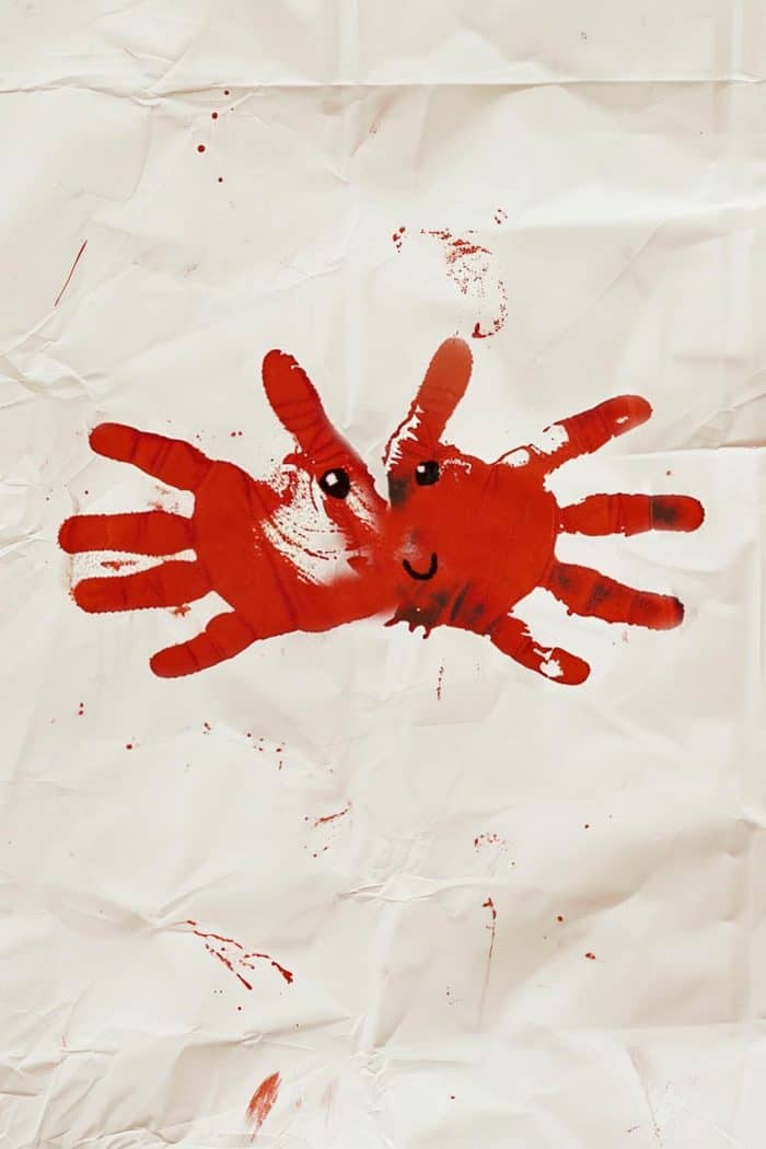 To create a handprint crab, paint your child's hands red and press them onto paper with fingers spread out to form the crab's legs. Once dry, add eyes and a smiley face on the palm area using paint or markers. 