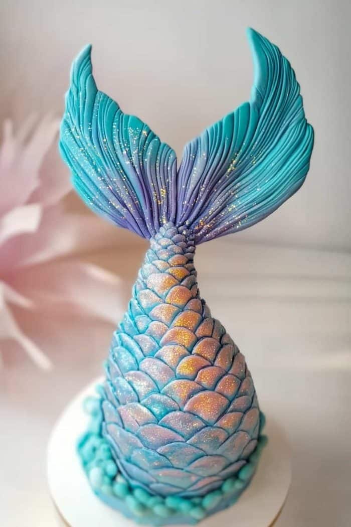 Here’s a true showstopper: a mermaid tail-shaped cake! It features intricately detailed fondant scales sprinkled generously with edible glitter that shimmers in the light. A magical creation that's sure to enchant everyone at your party!