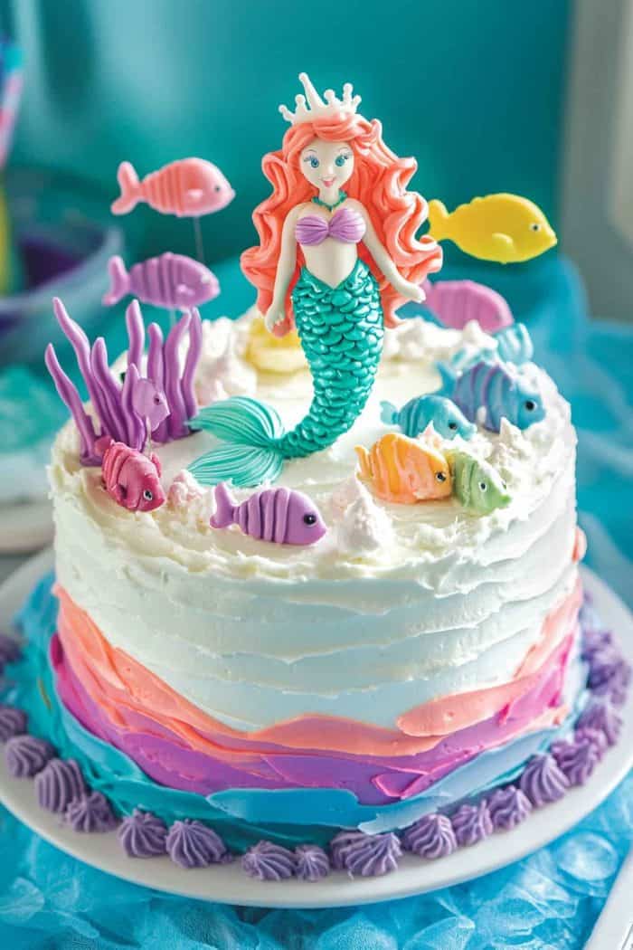 On top of this cake is a lively underwater scene with a mermaid surrounded by colorful fish — perfect for kids who love the ocean! To enhance the underwater effect, use white frosting to create bubbles. 