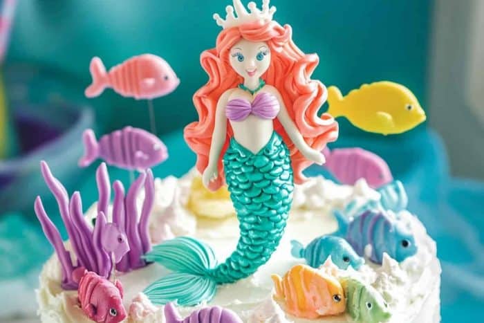 On top of this cake is a lively underwater scene with a mermaid surrounded by colorful fish — perfect for kids who love the ocean! To enhance the underwater effect, use white frosting to create bubbles. 
