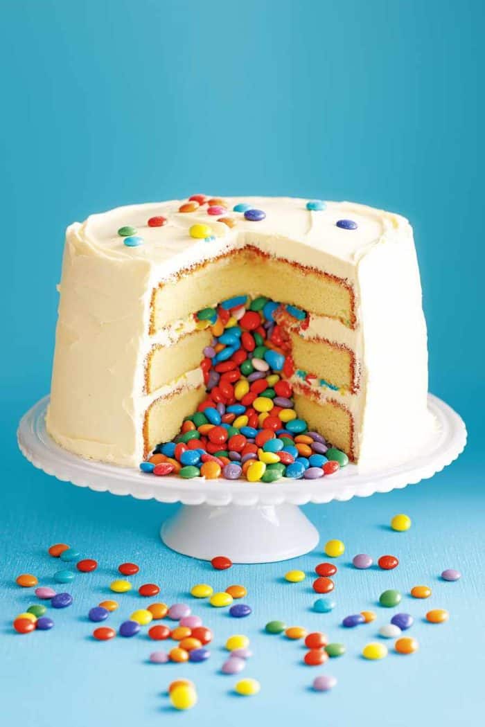 You can make this by hollowing out the center of your layered cake and filling the cavity with an assortment of rainbow-colored candies.